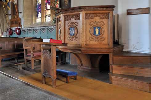 1010edBurton2 Inside the 15th century church, there is a 14th century Font with its 12th century base, as well as this a 20th century wooden pulpit, which makes for a historically interesting, if not always aesthetically harmonious, mix of styles.