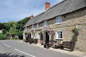 1010edBurton6 Burton Bradstock still keeps the spirit of a village, with its two pubs, post office and shop and school. The reason for the pub to share its emblem with the Worshipful Company of Farriers is lost in the mists of time.