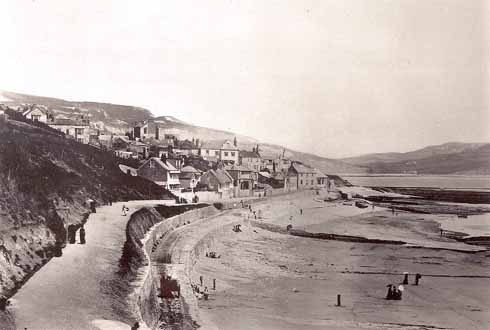 811edLyme4 The Walk looking eastwards in the 1870s with the cart road below it. In the near distance is a cart, but it is moving too quickly for the camera to have captured it crisply. Courtesy Lyme Regis Philpot Museum