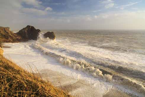 This was from the first set of storms in February 2014. As Andy recalls: ‘This shot is practically at low tide, despite the foam on the beach reaching the cliffs. There was a boulder – about the size of a commercial wheelie bin – being tossed in onto the beach and then out. In the morning, the waves (not the spray, but the waves) had been hitting the cliffs up to the level of the grass. The beach was completely flat after the storms. ’