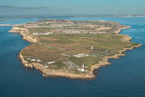 The beak-shaped southern tip of the Isle of Portland that is Portland Bill showing the three lighthouses and, further up, is the former Admiralty Underwater Weapons Establishment which is now known as Southwell Business Park and is home to a hotel and, from September 2016, will be the home of Isle of Portland Aldridge Community Academy, Portland's superschool