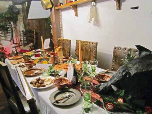 The table in the main room laid up for a Christmas feast, including a specially constructed boar’s head. The decorations feature holly and ivy, but no Christmas tree, streamers or glitter, all of which came well after the Tudor period.